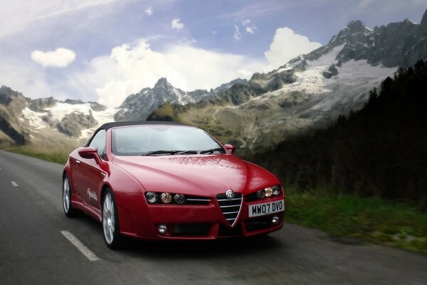 Auto rossa alfa romeo. Paesaggio sulle montagne