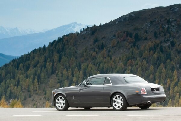 Elegante coche aparcado en el fondo de las montañas