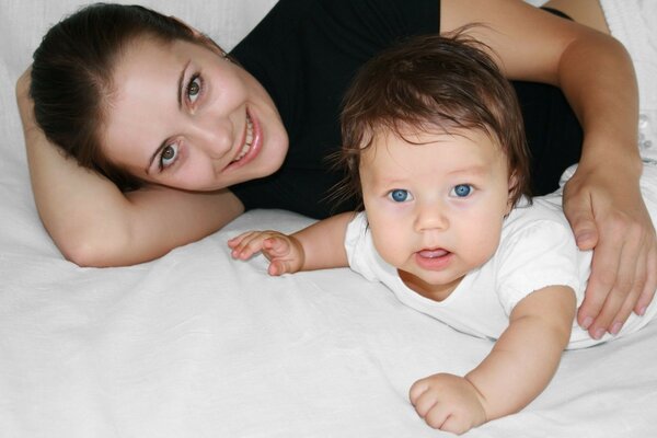 Mama und Baby liegen auf dem Bett