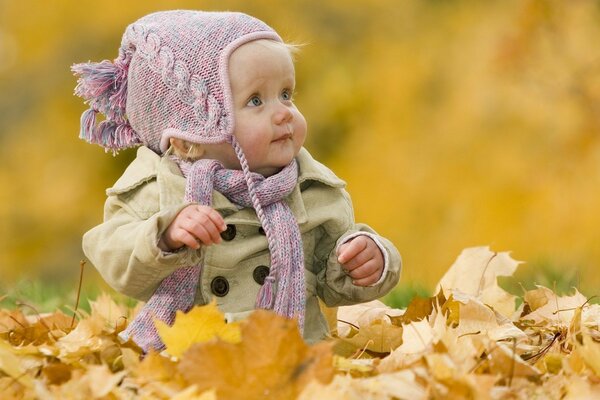 Bambino nel parco che gioca con le foglie