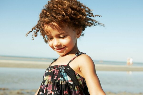 La princesa del verano es una chica rizada en la playa del mar