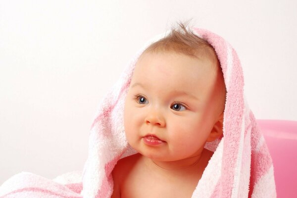 Mignon bébé dans une serviette rose