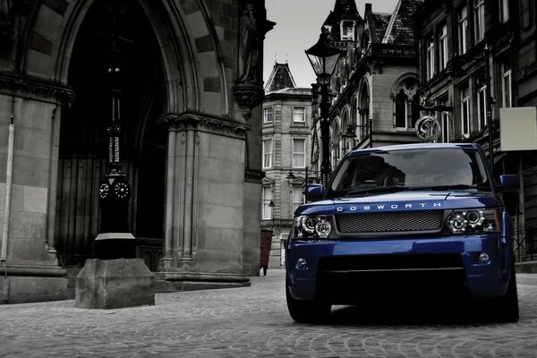 Blue range rover on the background of a monochrome city