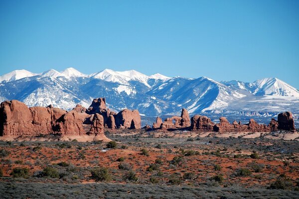 Blue mountains in the distance, red rocks in the foreground