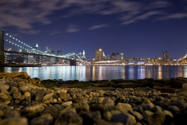 A modern city in lights is reflected in the water