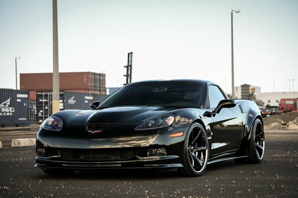 Черный chevrolet zr1 на фоне урбанистического пейзажа