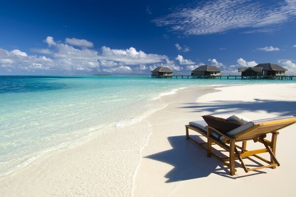 Chaise longue on the sand of the beach houses