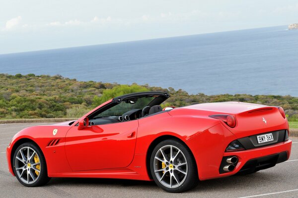 Красный ferrari калифорния на побережье