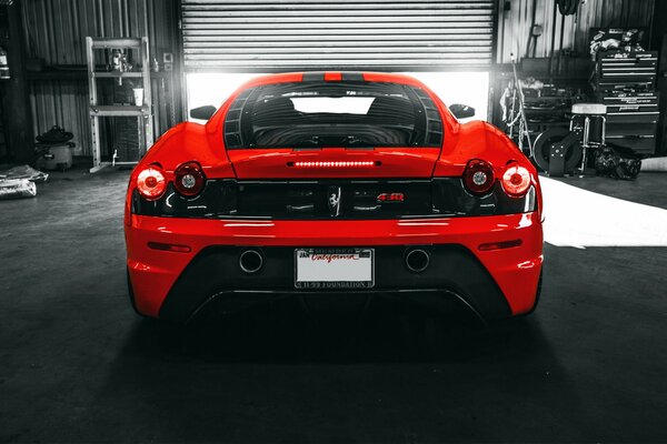 Итальянский красный спорткар ferrari f430 в гараже