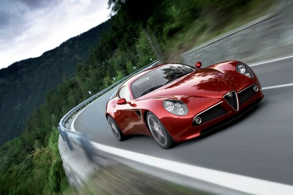 Қызыл Alfa Romeo көлігі жоғары жылдамдықпен жүреді