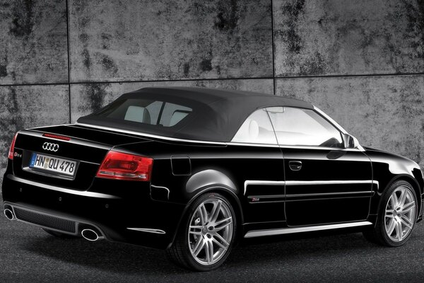 Black Audi car rear view on the background of a concrete wall