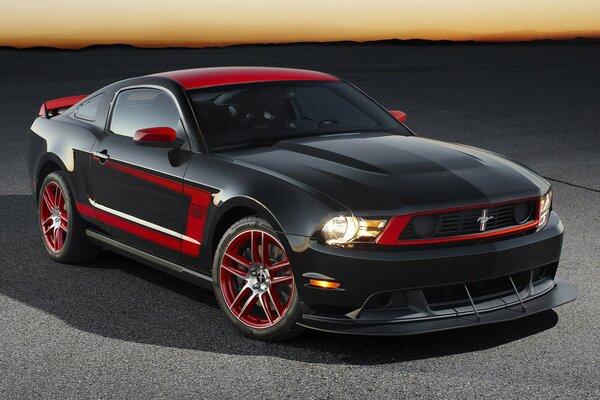 Ford mustang in black and red on sunset background