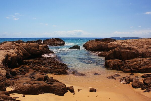 Playa con piedras contra el mar