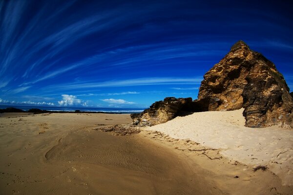 Plage de sable avec un rocher sur l océan