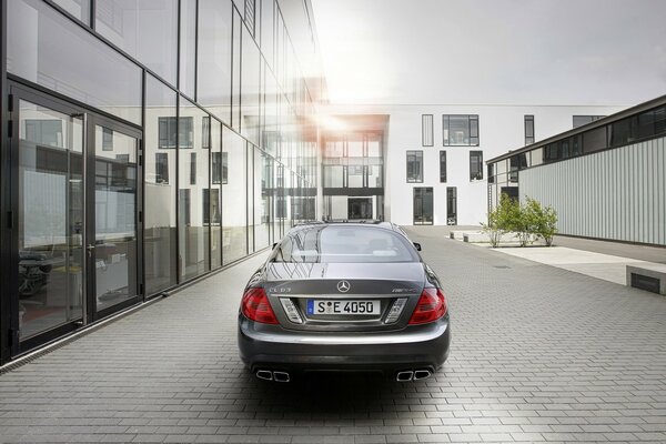 Mercedes-Auto auf grauem Hintergrund in der Nähe eines Glasgebäudes