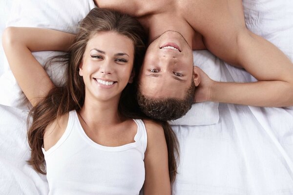 Homme et femme se trouvent sur le lit