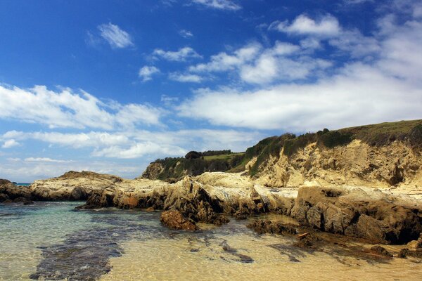 Sandy cliff on the shore calm water