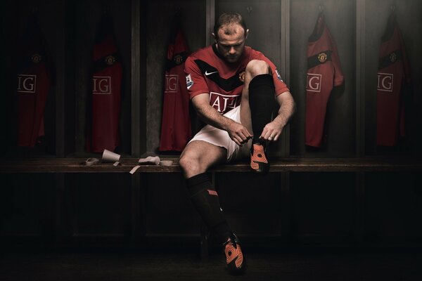 Football player ties shoelaces on shoes