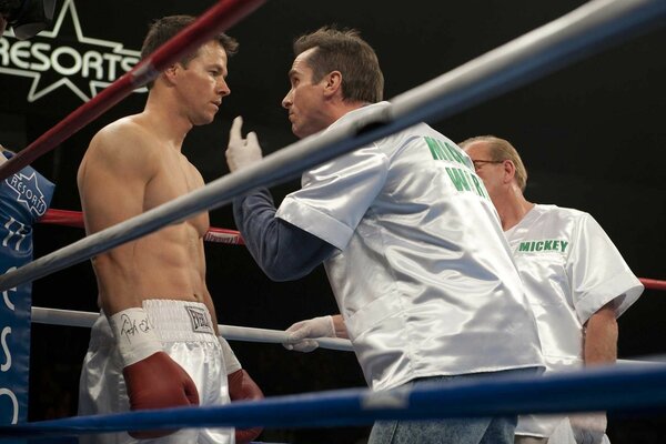 Boxing ring, a fighter is being prepared for a fight, a conversation with a trainer