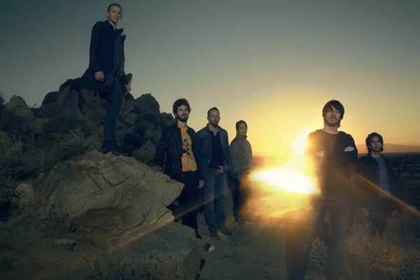 Una banda de rock al atardecer toma una foto de grupo