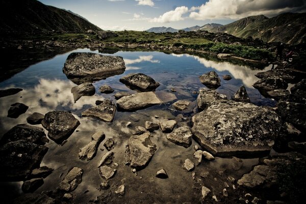 Landschaft von Steinen auf dem Wasser mit reflektierendem Himmel