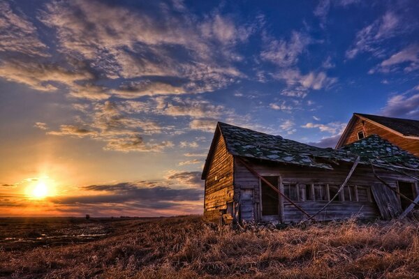 Sunset on the background of cirrus clouds and abandoned buildings