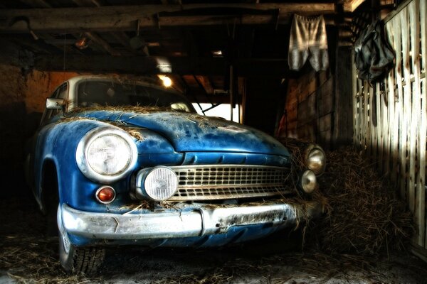 Carro retro empoeirado azul na garagem