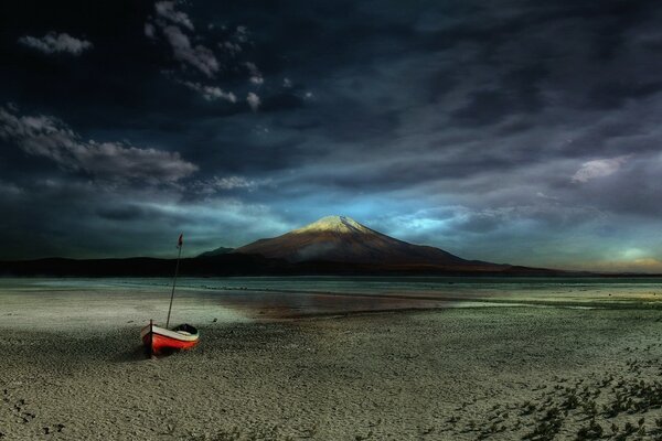 Playa con un barco solitario al atardecer