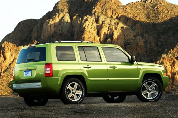 Grüner Jeep auf dem Hintergrund der Berge