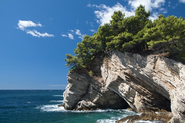 The rock goes into the sea and the waves caress it