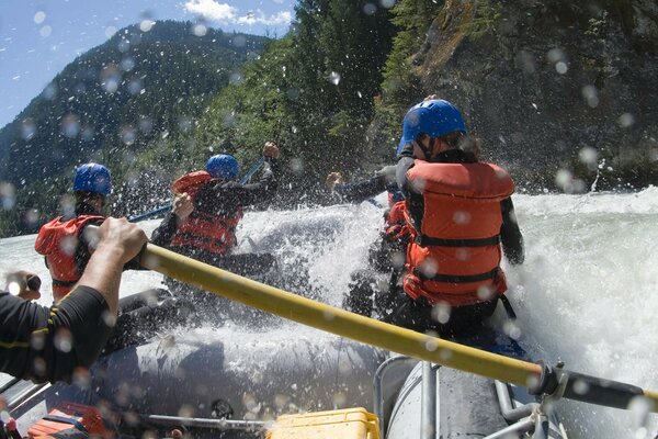 People in vests in a boat, rowing