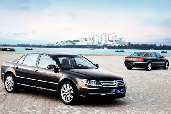 Two cars on the background of the city and the river