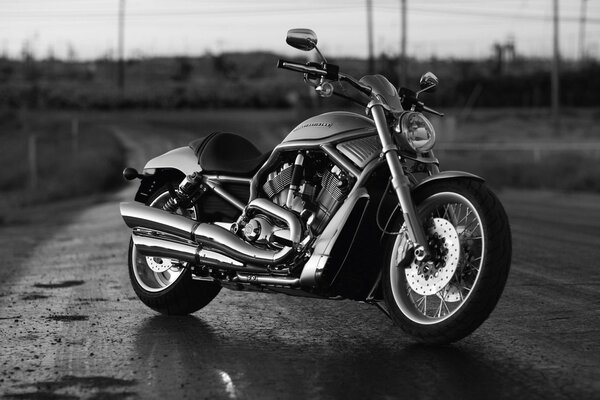 Photo en noir et blanc d une moto sur une route vide