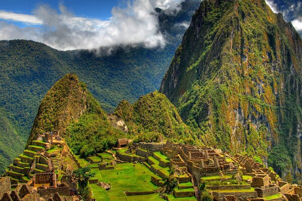 Ancient Mayan buildings on the background of mountains and sky