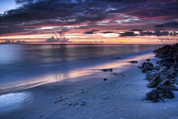 Plage déserte de sable sur fond de coucher de soleil lumineux