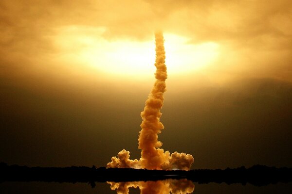 Bright clouds of smoke are reflected in the water and go into the sky