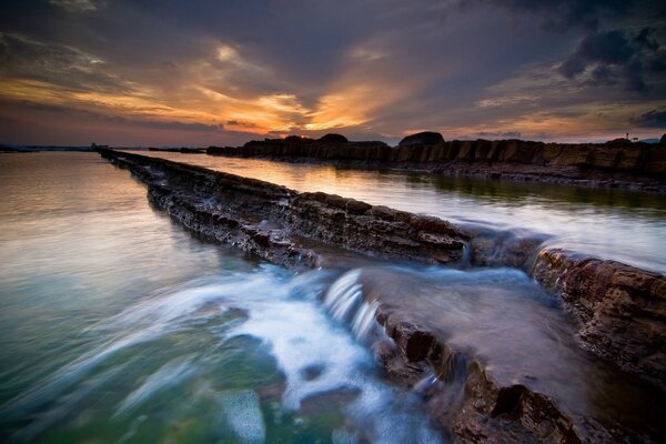 Ein Fluss mit Stromschnellen. Sonnenuntergang. Wasserfall