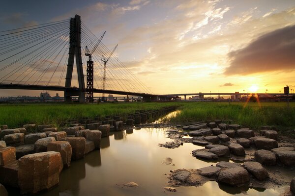 Pôr do sol brilhante sobre a ponte na cidade