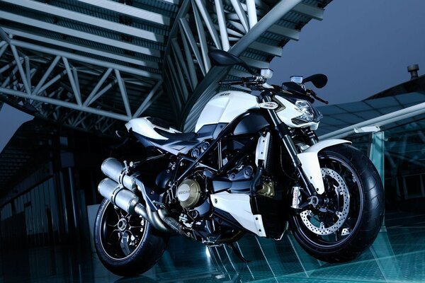 Stylish motorcycle on the background of metal structures