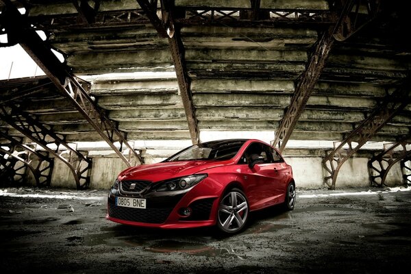 Voiture rouge dans un bâtiment abandonné