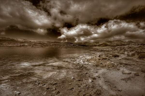 Dunkle Strand- und Berglandschaft