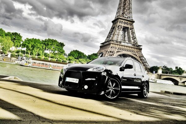 Black Porsche on the background of the Eiffel Tower