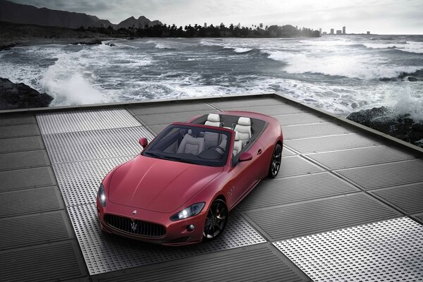 Red Maserati convertible by the water