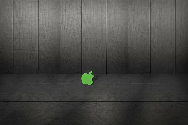 Зелёный логотип apple на фоне досок