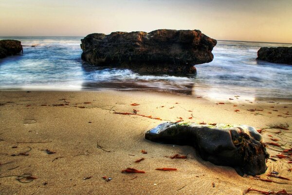 Tramonto sul mare con surf attraverso le rocce