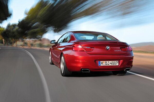 Rear view of a red BMW with a blurry background