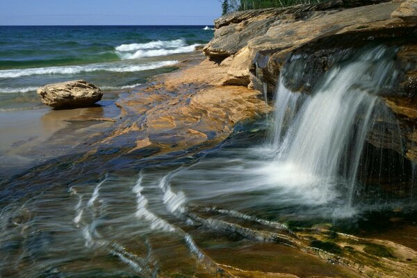 The waterfall flows into the ocean