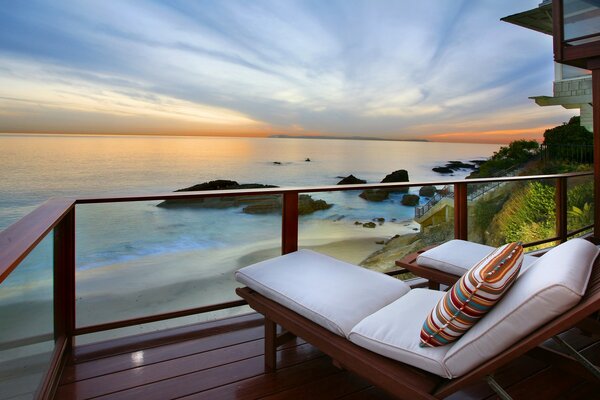 Espreguiçadeiras no terraço da casa com vista para o mar