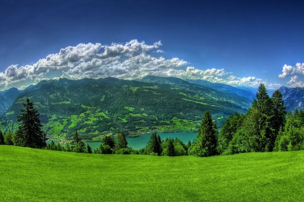 Paisagem montanhosa. Nuvens brancas, Prado alpino e montanhas no horizonte