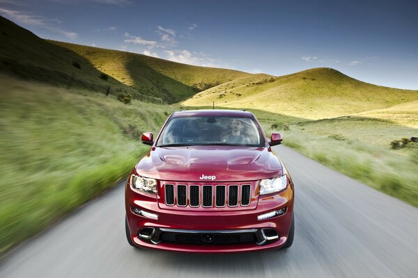 Red jeep rides on asphalt